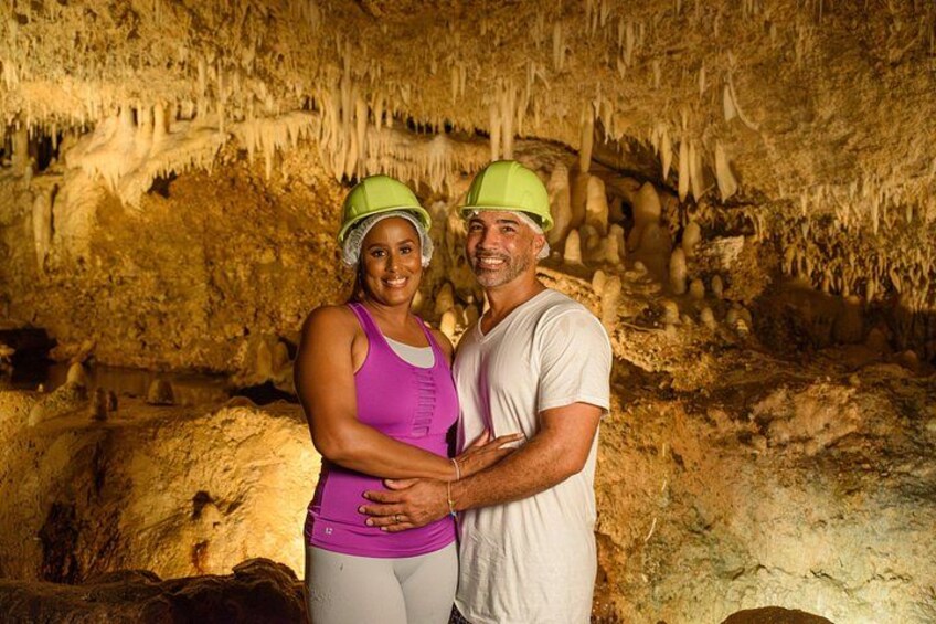 Two people in a cave with stalactites and stalagmites. 1