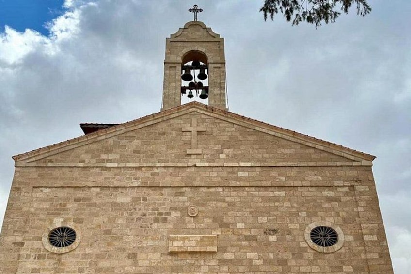 A church with a bell tower, arched window, and two circular windows. 1