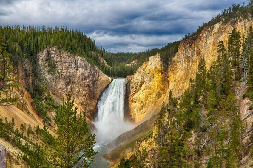 A waterfall surrounded by forested cliffs. 1