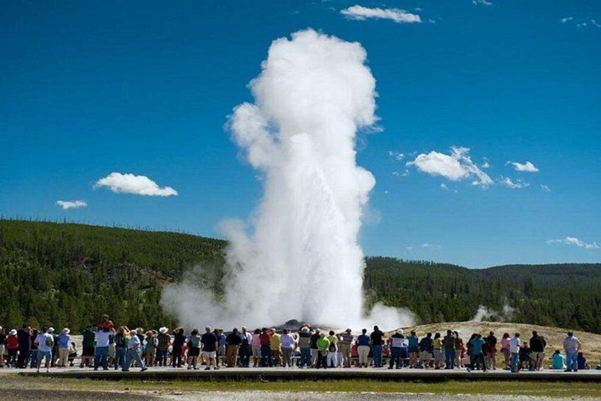 A geyser erupting with a crowd watching. 4
