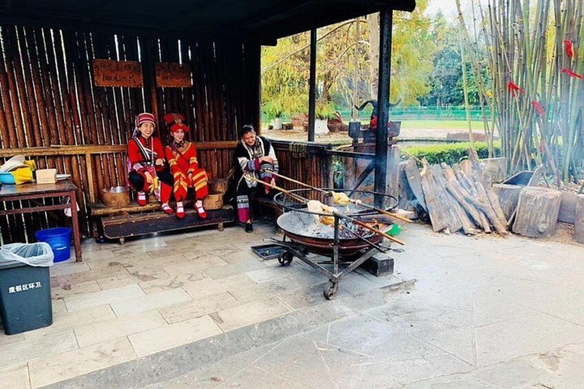 A traditional cooking setup with a grill, a wooden bench, and a rustic shelter. 4