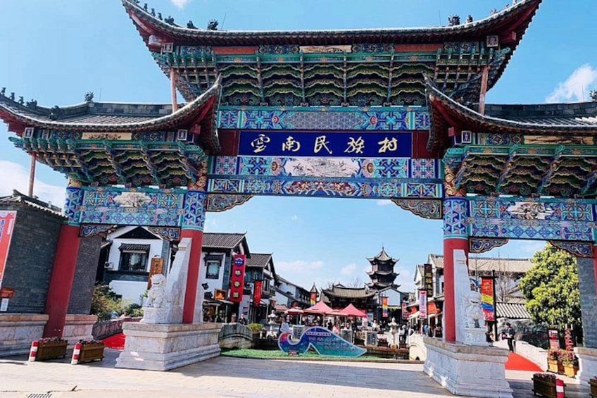 A traditional Chinese gate with intricate designs and a sign above it. 1
