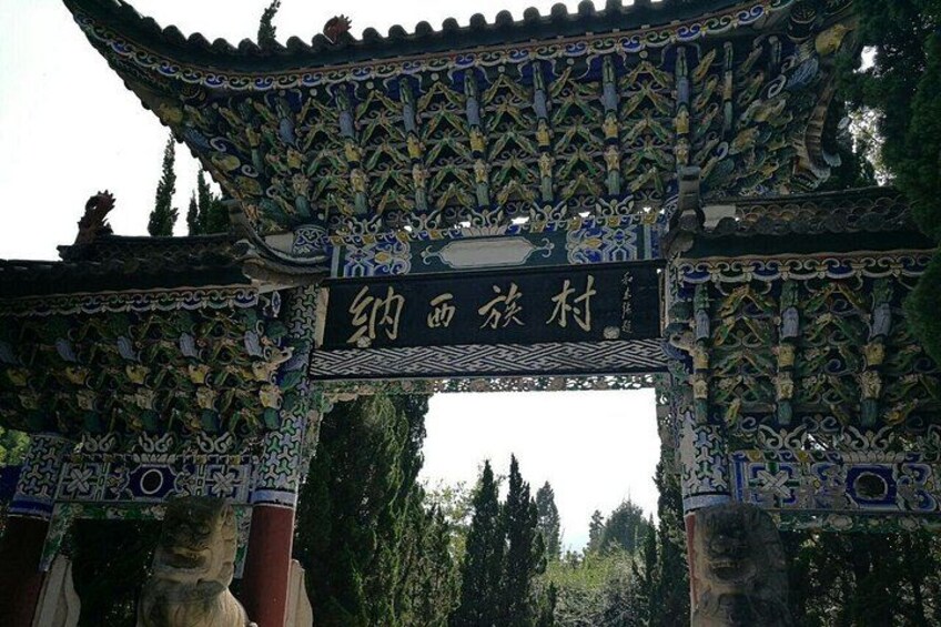 A traditional Chinese gate with intricate designs and a sign with Chinese characters. 3
