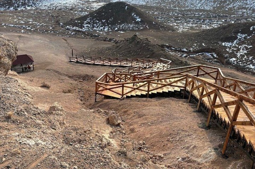 A wooden staircase leading up a rocky hillside with a small shelter at the top. 3