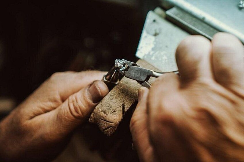 Hands using a tool on a piece of metal, possibly for crafting or repair. 3