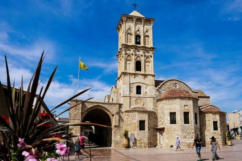 A historic church with a bell tower, a large arched entrance, and a flag. 2