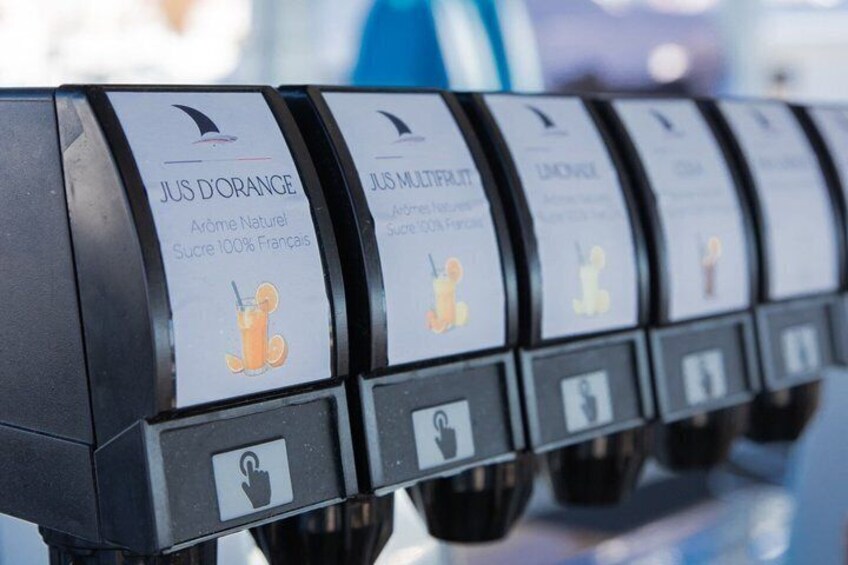 Une rangée de distributeurs, chacun portant une étiquette indiquant le nom d’un parfum de jus différent. 2