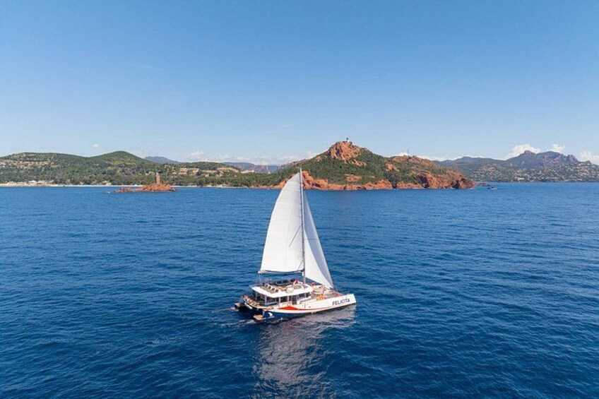 A sailboat on a calm sea with a mountainous coastline in the background. 2