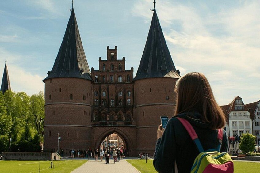 A historic brick building with two prominent towers and a central archway. 3
