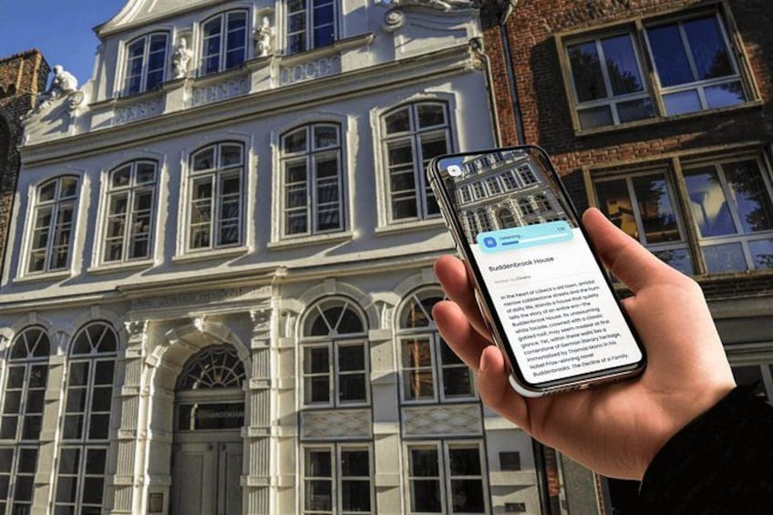 A hand holding a smartphone with a message about a building. 5