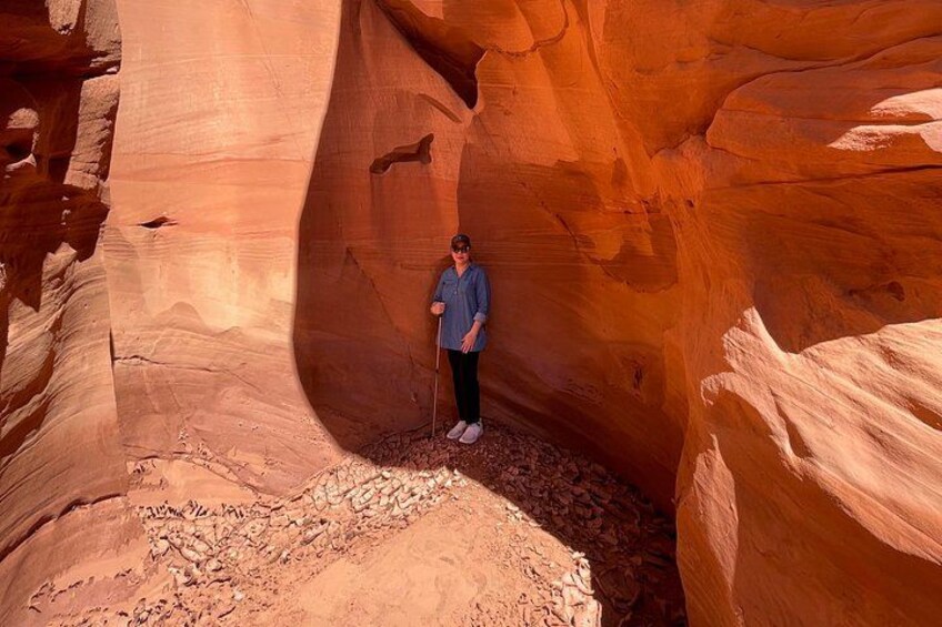 A person standing in a narrow canyon with red rock walls. 4