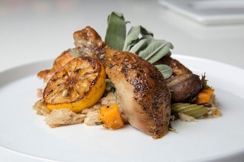 A roasted chicken with vegetables and herbs on a plate. 3