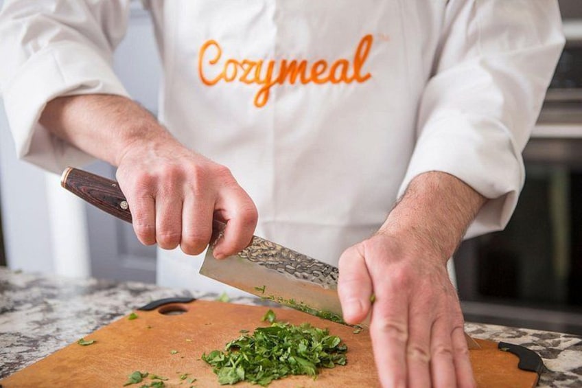 A person chopping herbs on a cutting board. 2