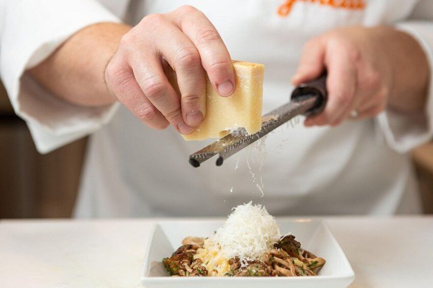 A person grating cheese over a dish. 3