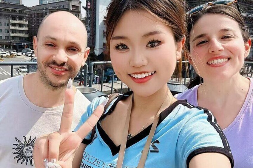 Three people taking a selfie with a cityscape in the background. 3