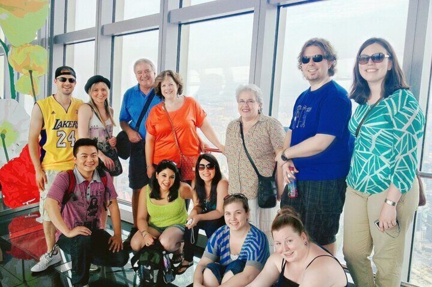 A group of people posing in a high-rise building with large windows. 3