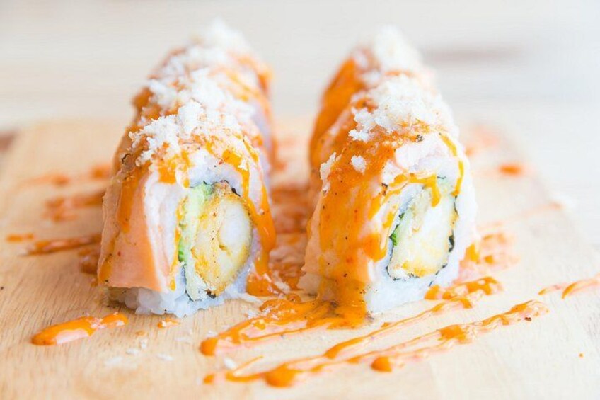 Rollitos de sushi con salsa sobre una tabla de madera. 2