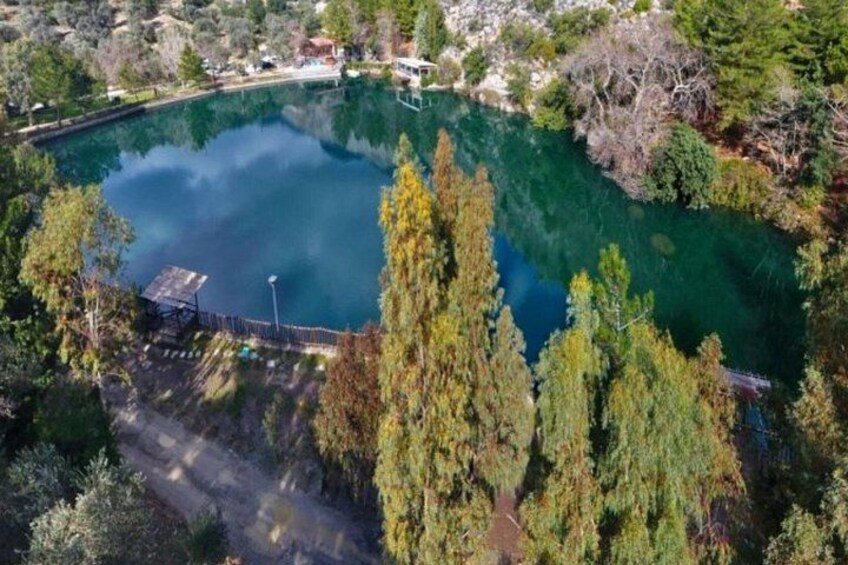 A large, clear lake surrounded by trees and a dock. 3