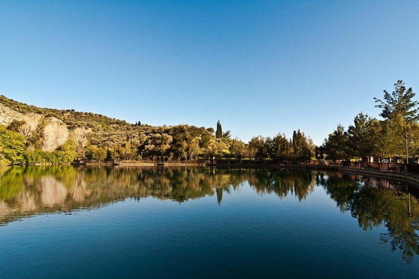 A calm lake with clear reflections, surrounded by trees and hills. 2