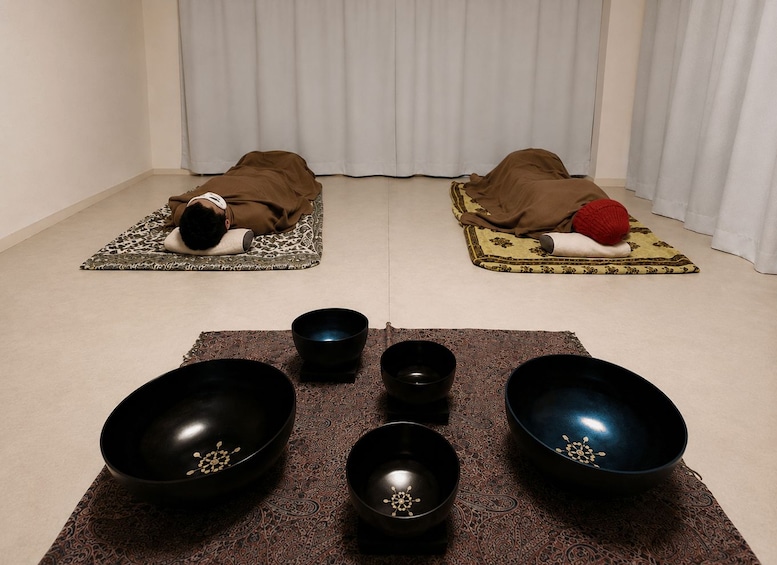 Two people lying on mats with bowls in front of them. 5