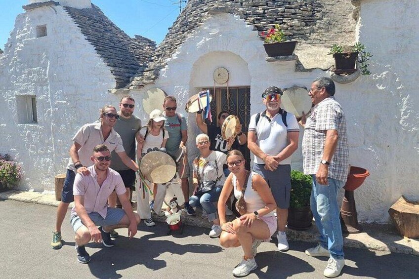 A group of people posing in front of a white building with a sloped roof. 2
