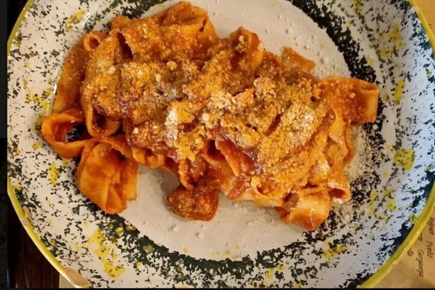 A plate of pasta with a tomato-based sauce and grated cheese. 5