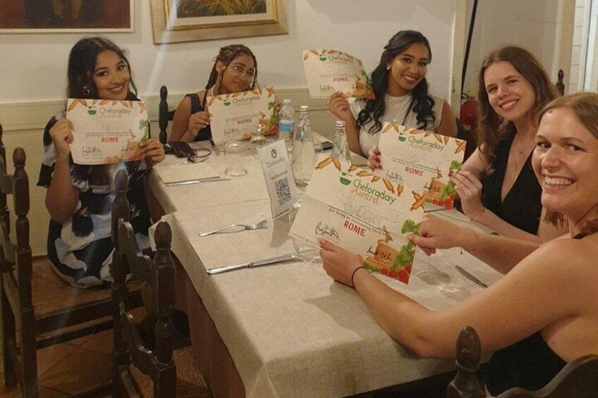 A group of people holding branded cards at a table with a nameplate, glasses, and a water bottle. 4