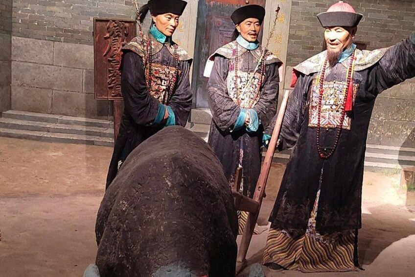 A historical reenactment with individuals in traditional costumes, a wooden horse, and a backdrop of stone walls. 4