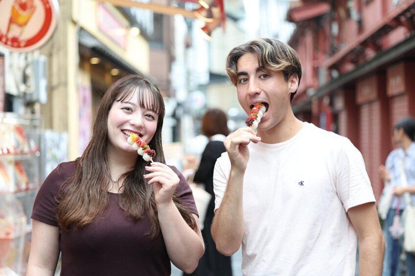 Two people eating ice cream in an urban street setting. 1