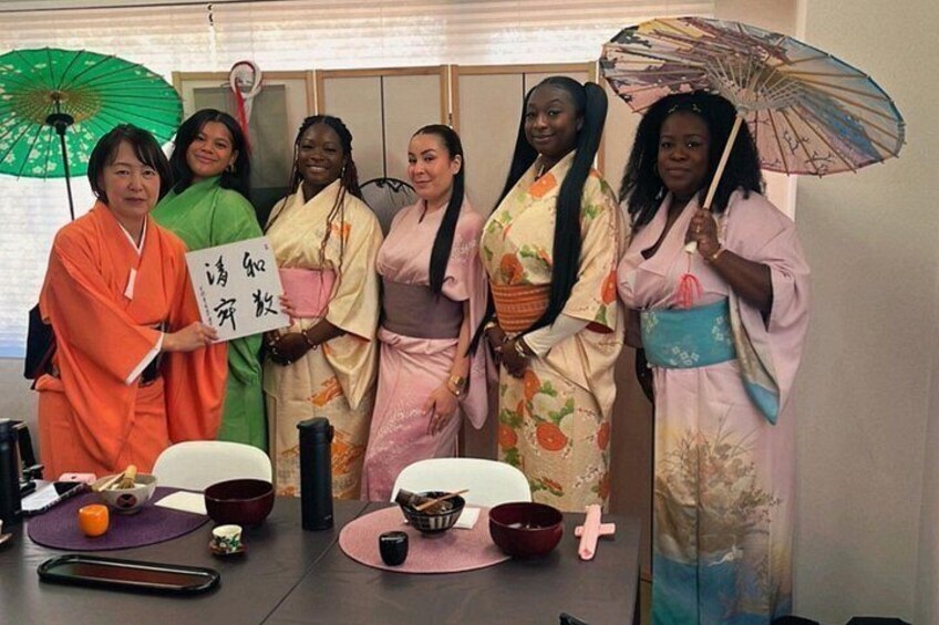 Un grupo de personas vestidas con atuendos tradicionales reunidas alrededor de una mesa con diversos objetos. 4