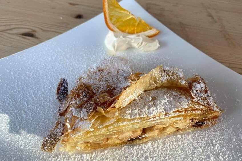 A dessert with powdered sugar and a slice of orange on a white plate. 3