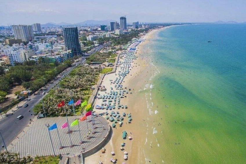 Un paisaje costero con playa, edificios urbanos y cielo despejado. 5