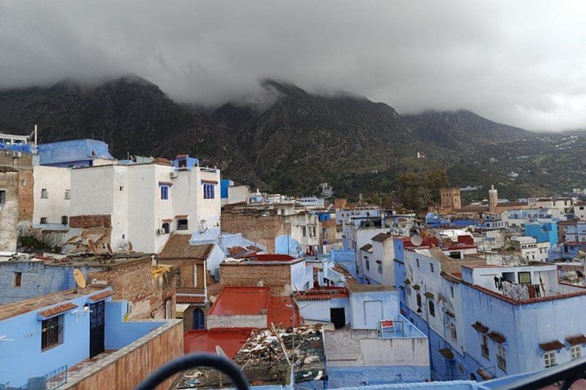 A town with colorful buildings, a mountain in the background, and a cloudy sky. 3