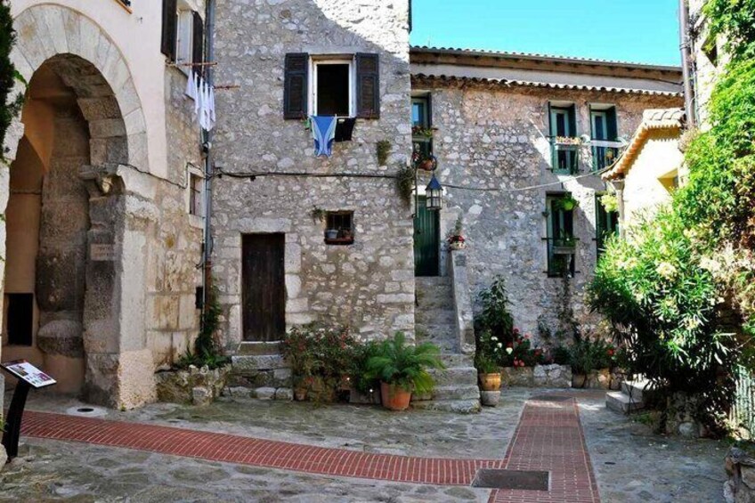 Un edificio in pietra con un vialetto in mattoni rossi, un'ampia arcata e piante in vaso. 3