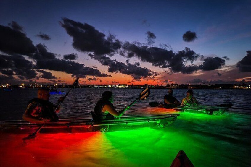 A sunset over water with people rowing a boat. 5