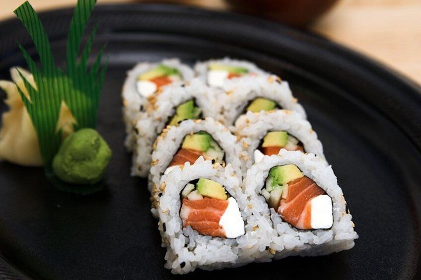 Sushi rolls with avocado and salmon on a black plate. 2