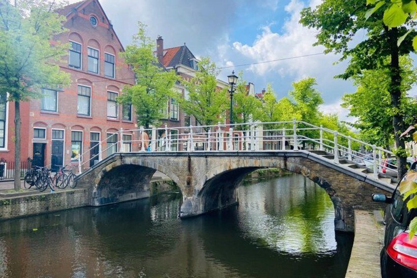 Eine Steinsbrücke über einen Kanal, umgeben von Bäumen und Gebäuden. 4