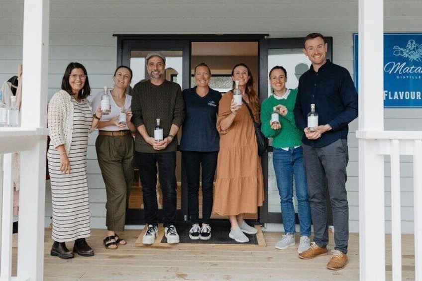 A group of people standing on a porch holding bottles. 4