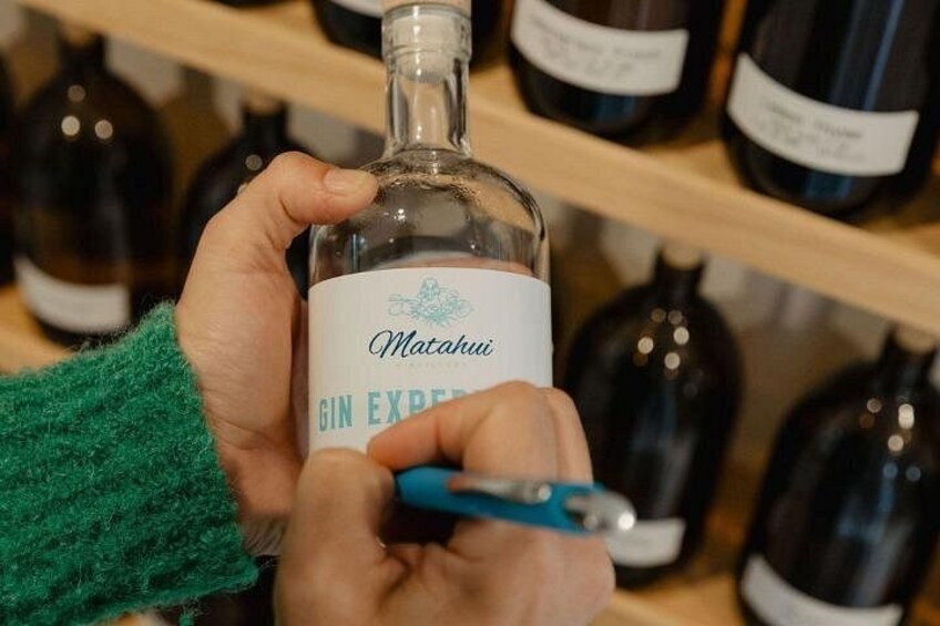 A person holding a bottle of Matahui Gin Express. 2