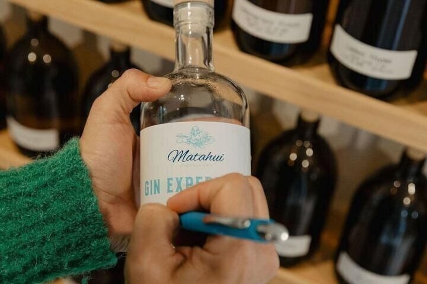 A person holding a bottle of Matahui Gin Express. 3