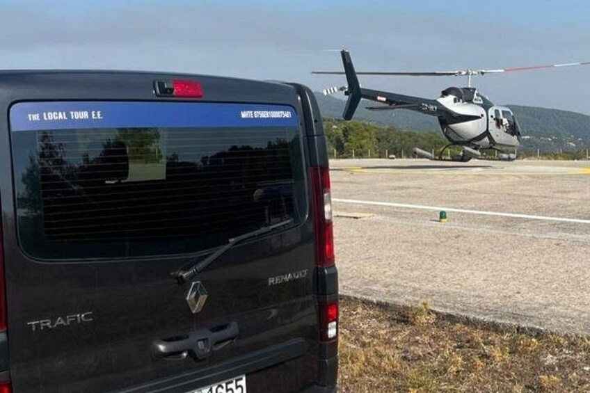 A black Renault Trafic van with a helicopter in the background. 3