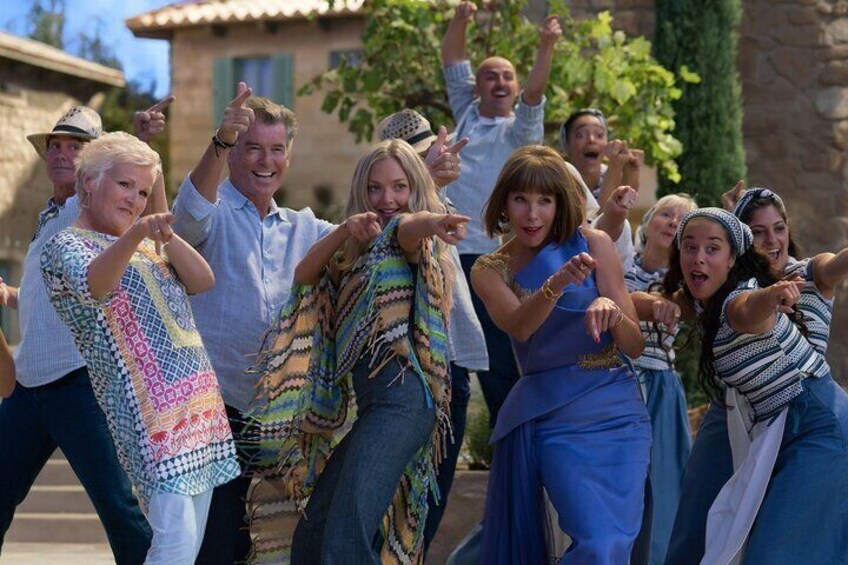 A group of people dancing outdoors in a casual setting. 1