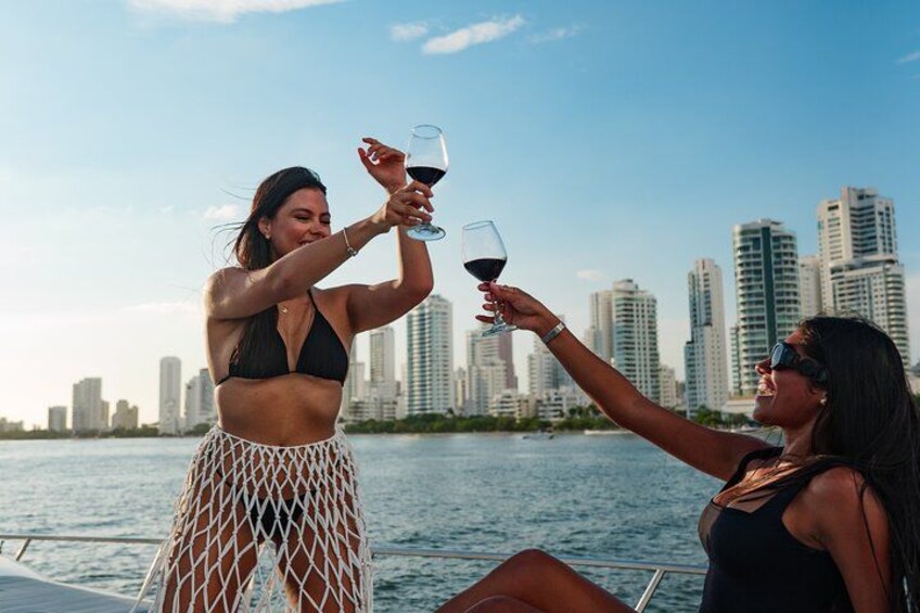 Two people toasting with wine glasses on a boat with a city skyline in the background. 3