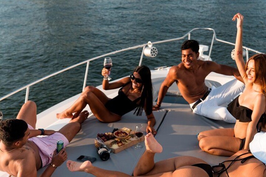 A group of people relaxing on a boat with drinks and snacks. 2