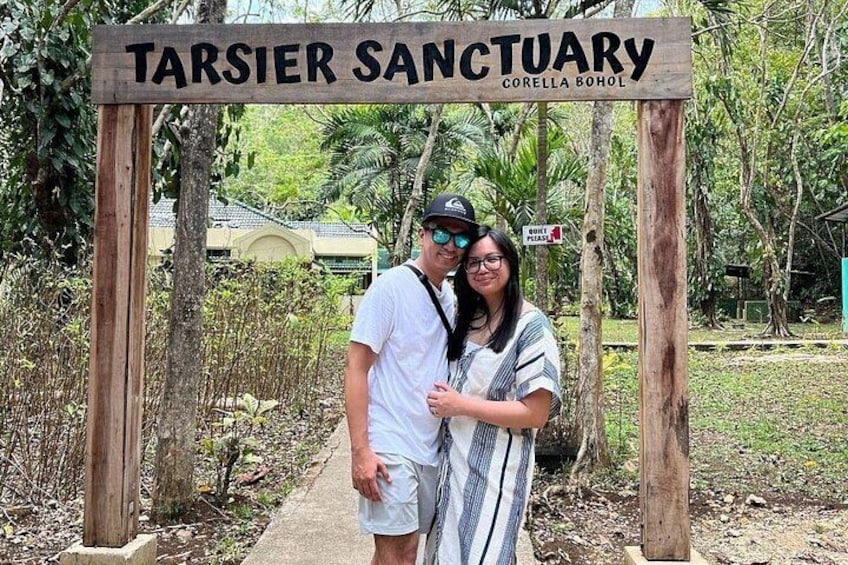 A couple smiles under the wooden archway of the Philippine Tarsier Sanctuary in Corella, a conservation area dedicated to the tiny primate. 3