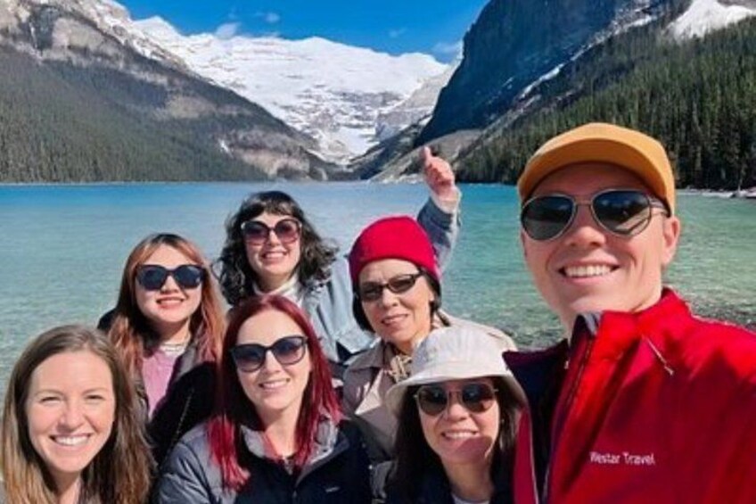 A group of people on a boat with a mountainous landscape in the background. 3