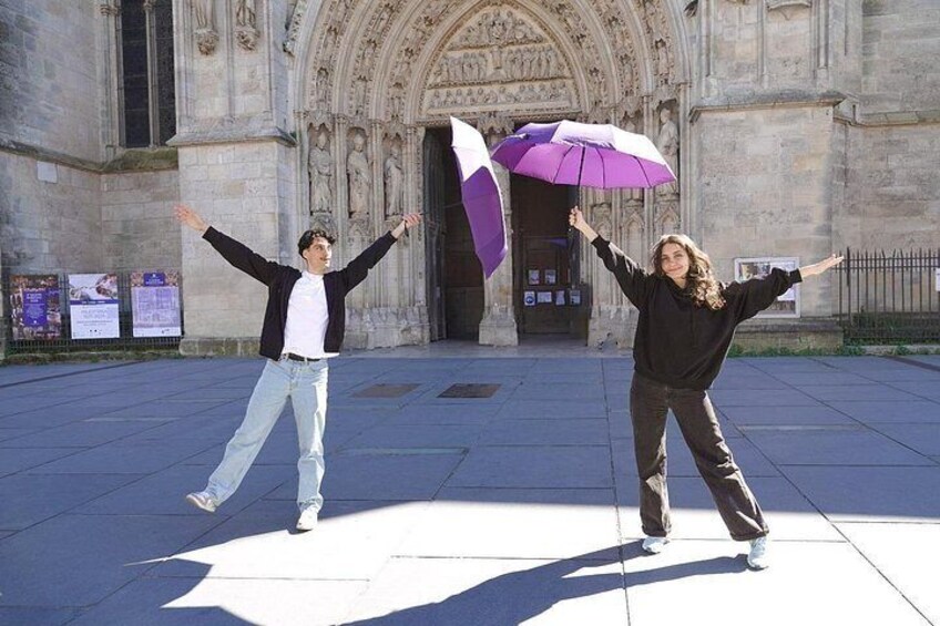 Two people dancing in front of a historic building with a large arched entrance. 3