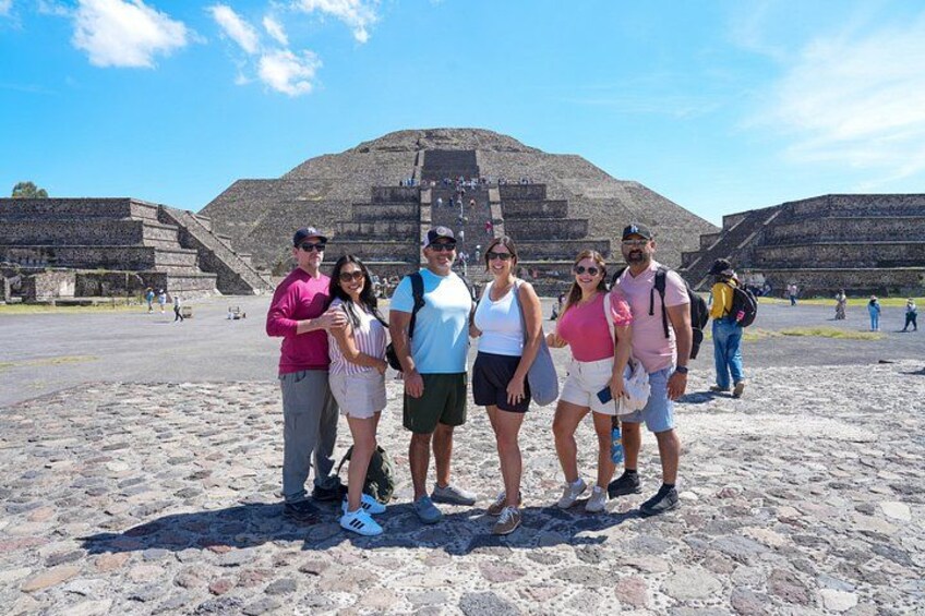 A group of people standing in front of a large pyramid structure. 2