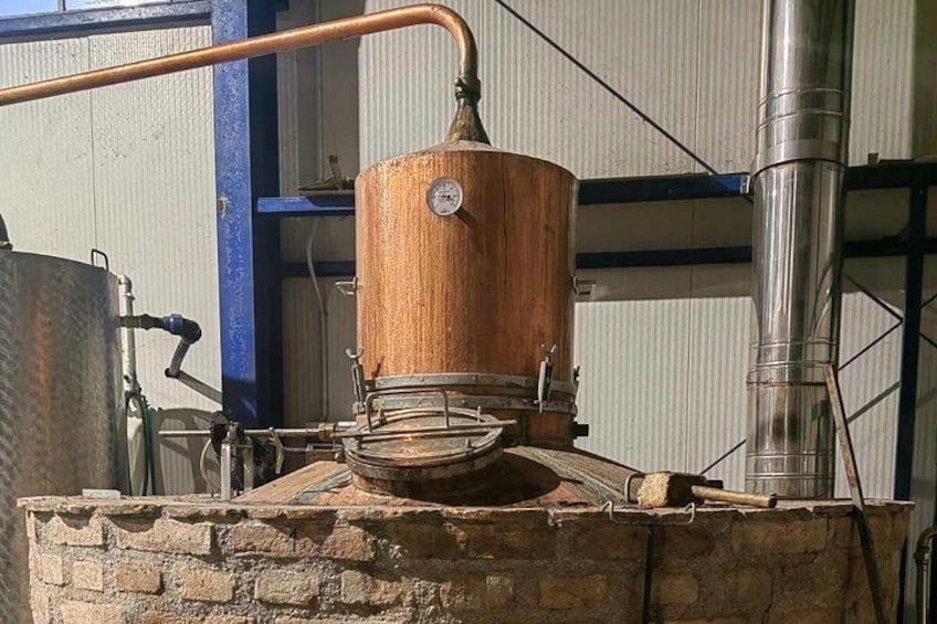 Un aparato de destilación de cobre con base de madera, un termómetro y un embudo de vidrio. 2