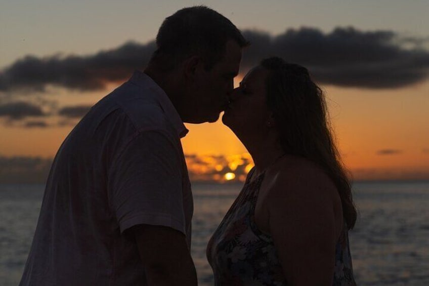 Ein Paar küsst sich bei Sonnenuntergang am Meer. 1